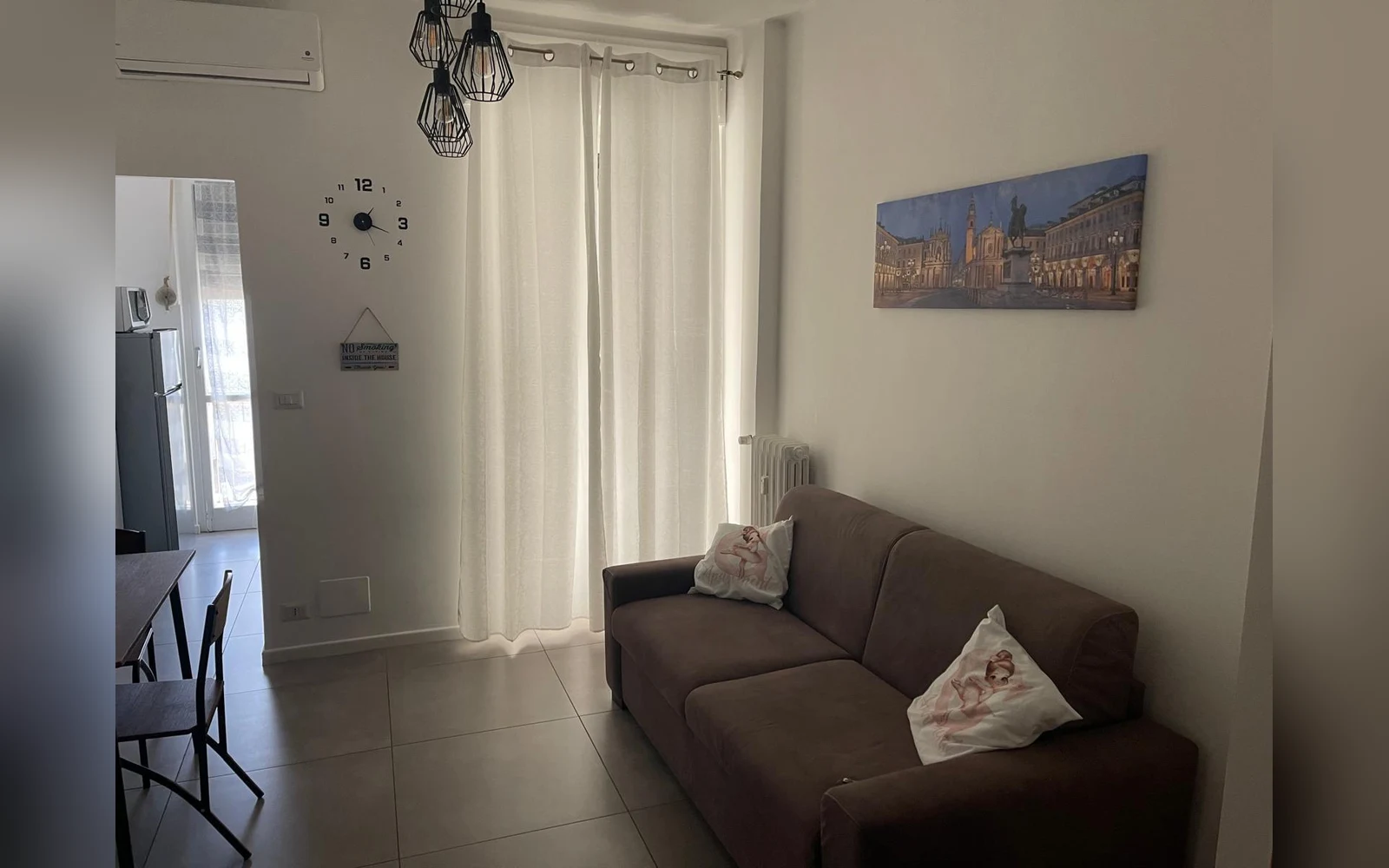 La sala di Ginevra Apartment con divano letto e quadro di Piazza San Carlo