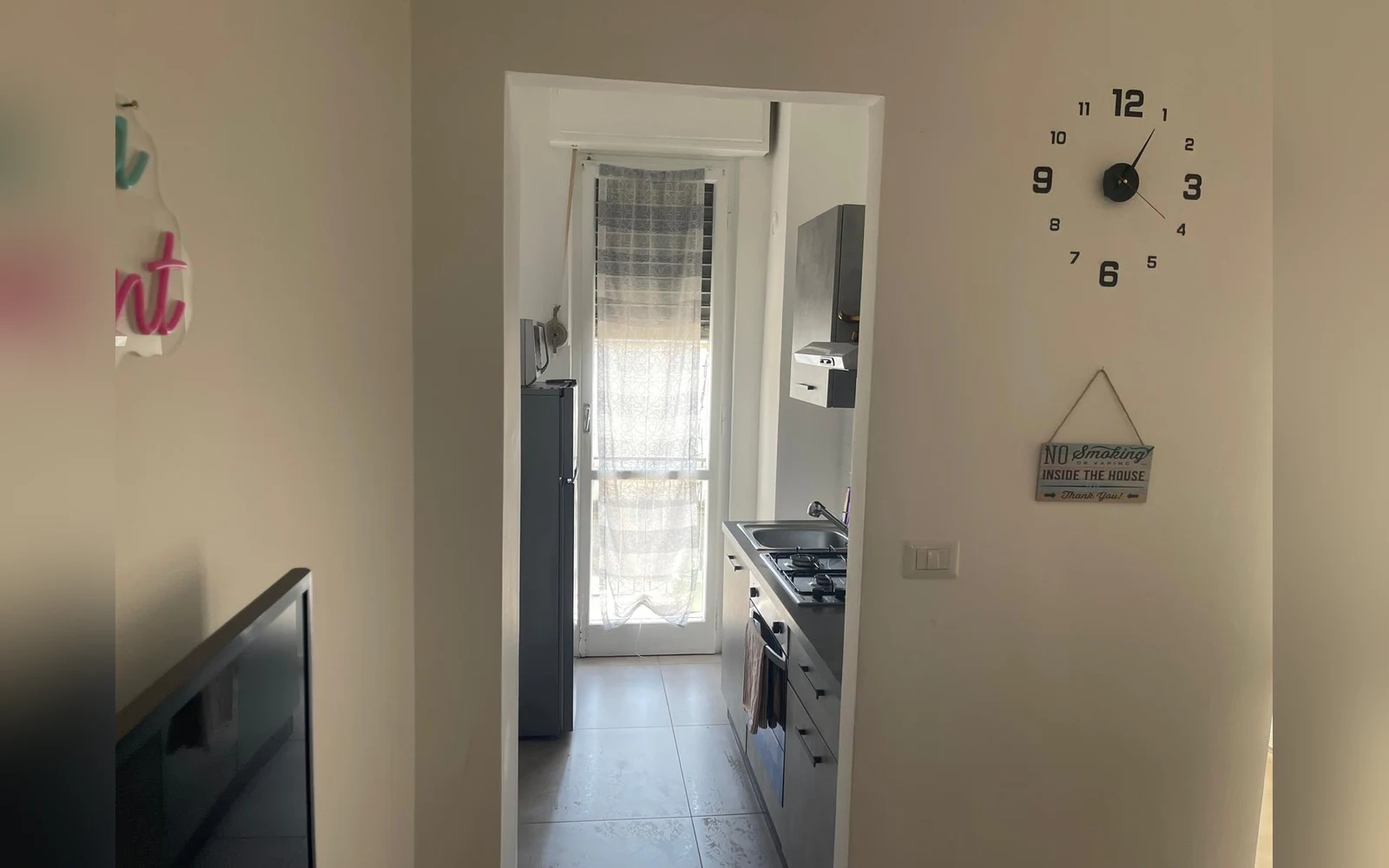 La cucina attrezzata con piano cottura, forno e porta finestra sul balcone